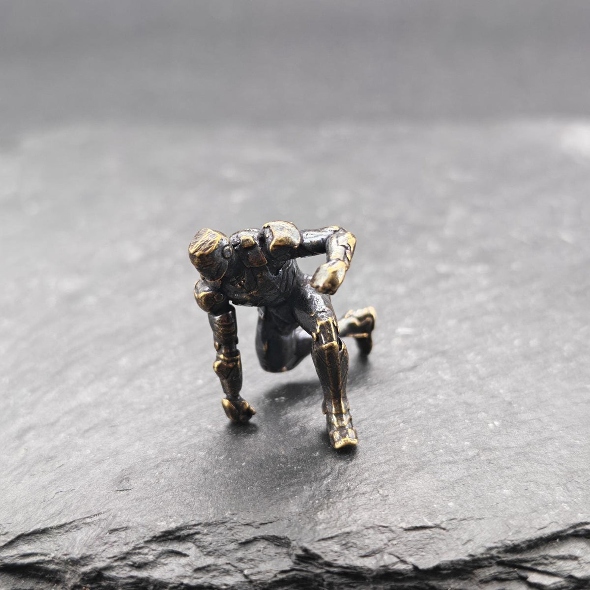 Brass Kneeling Armoured Hero Figurine — Red & Gold Exosuit Desk Collectible
